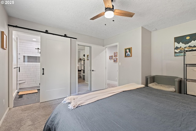 406 Balsa St, La Grande, OR 97850 - bedroom featuring carpet floors, a textured ceiling, a barn door, connected bathroom, and a ceiling fan