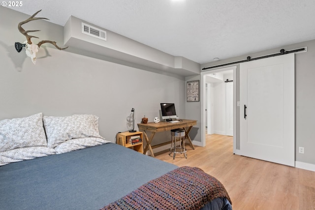 406 Balsa St, La Grande, OR 97850 - bedroom with light wood finished floors, a barn door, and baseboards