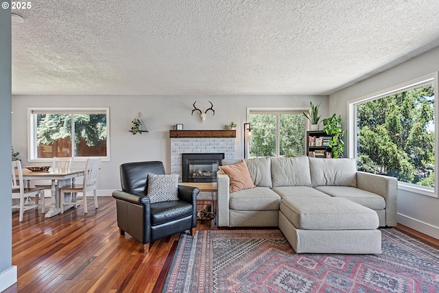 406 Balsa St, La Grande, OR 97850 - living room with hardwood / wood-style floors, baseboards, a textured ceiling, and a brick fireplace