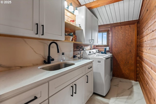 laundry room featuring washing machine and clothes dryer, marble finish floor, a sink, and cabinet space