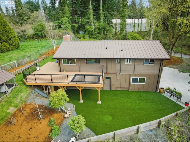 exterior space with a lawn, a chimney, and a deck