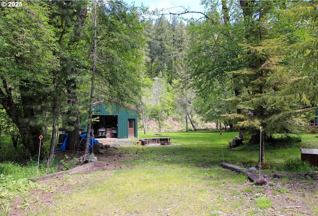 84932 Straw Springs Ln, Milton-Freewater, OR 97862 - view of green lawn featuring a detached garage, an outbuilding, and a forest view