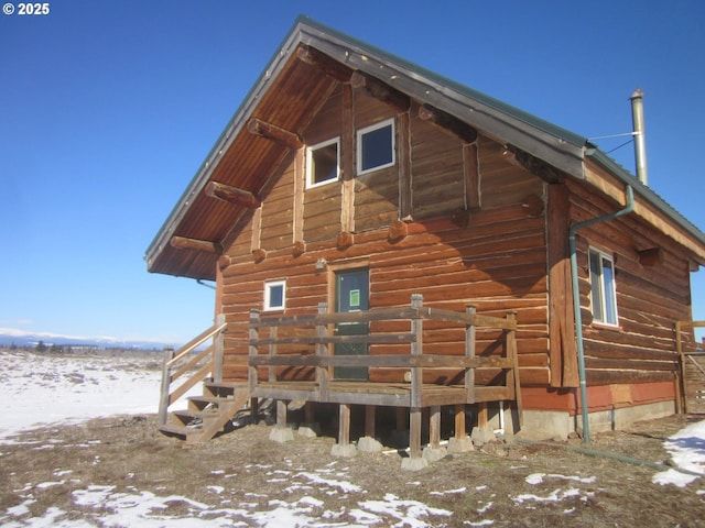 view of snow covered exterior featuring log exterior