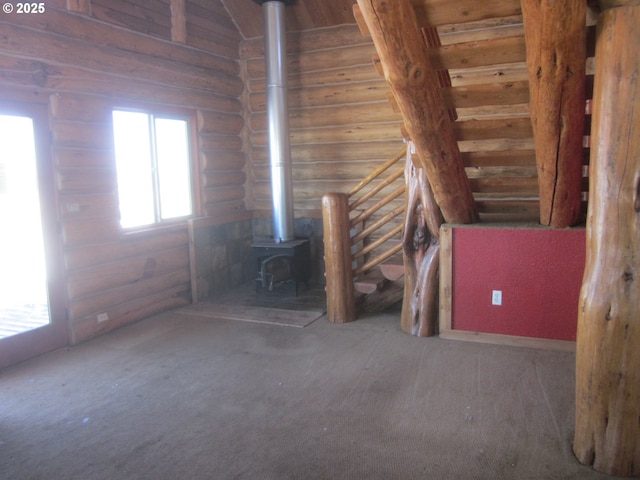 misc room featuring a wood stove and dark carpet