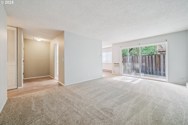 13155 SW Allen Blvd, Beaverton, OR 97005 - spare room with carpet, a textured ceiling, baseboards, baseboard heating, and a wall unit AC