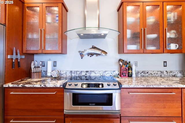 kitchen featuring stove, island range hood, and light stone counters