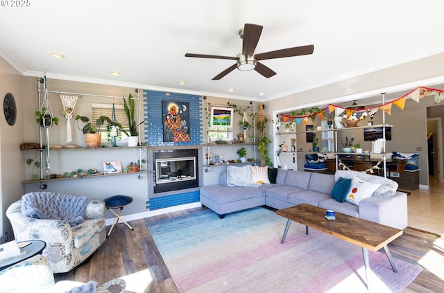 living room with wood-type flooring, ornamental molding, and ceiling fan