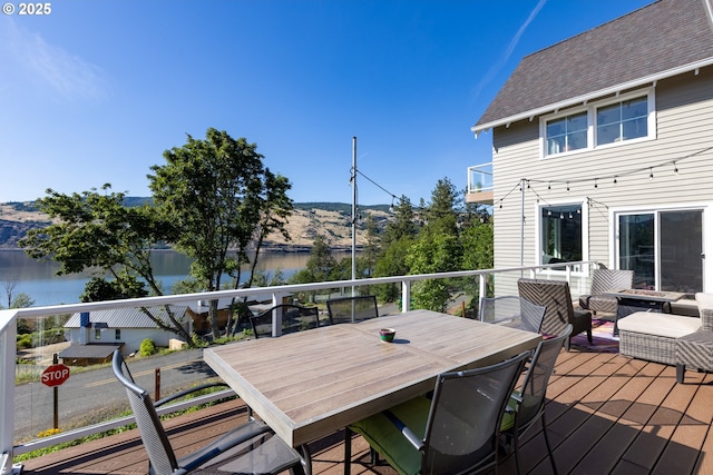 deck featuring an outdoor living space and a water view