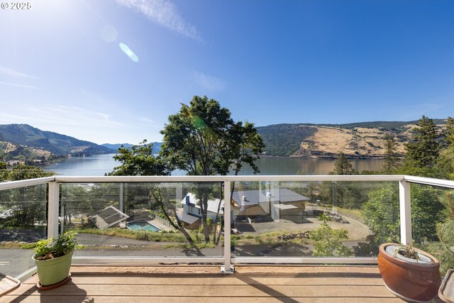 wooden deck with a water and mountain view