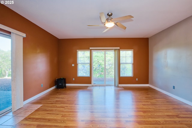 spare room with baseboard heating, ceiling fan, and light wood-type flooring