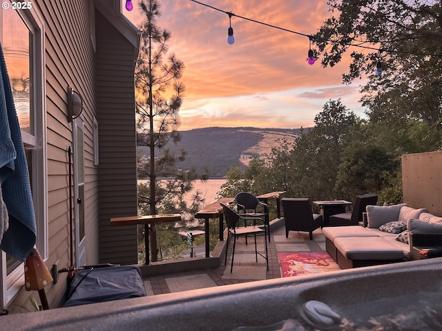 patio terrace at dusk with an outdoor living space and a mountain view