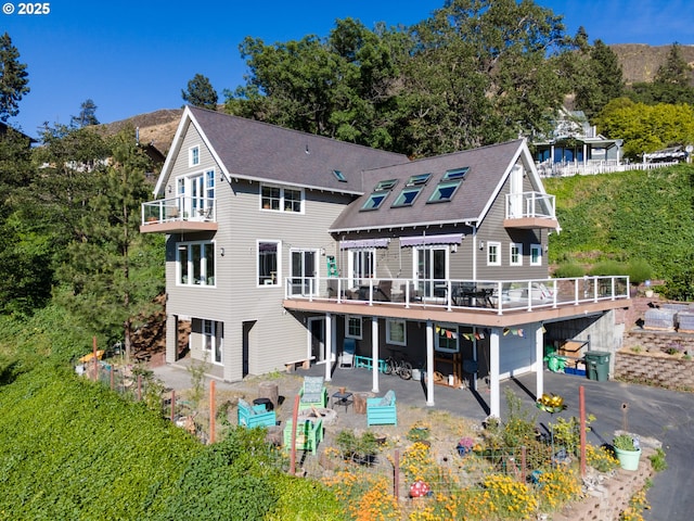 rear view of property featuring a patio and a deck