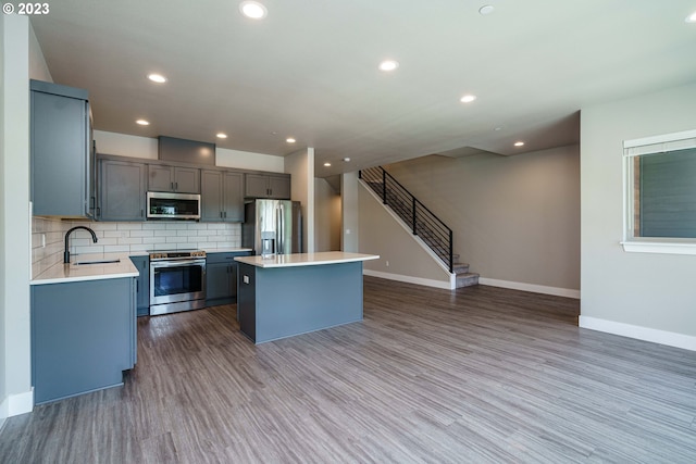 302 N Bridgeton Rd, Portland, OR 97217 - kitchen featuring stainless steel appliances, gray cabinetry, a center island, wood finished floors, and recessed lighting