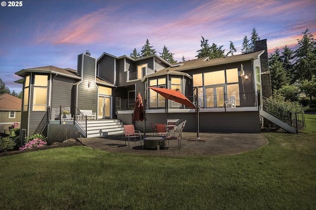 8623 Blackhawk Ct SE, Salem, OR 97317 - back of house at dusk with stairway, a chimney, a sunroom, and a patio