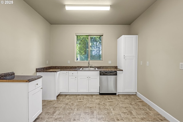 8623 Blackhawk Ct SE, Salem, OR 97317 - kitchen with stainless steel dishwasher, a sink, dark countertops, white cabinetry, and baseboards