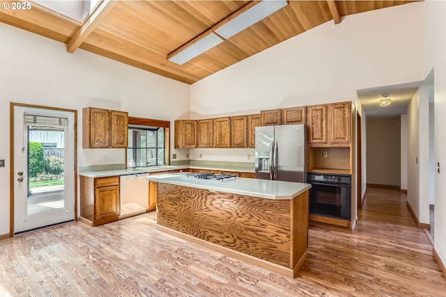 17708 SW Meadowbrook Way, Beaverton, OR 97078 - kitchen with white dishwasher, black oven, stainless steel refrigerator with ice dispenser, high vaulted ceiling, and wood ceiling with exposed beams