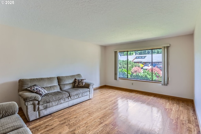 17708 SW Meadowbrook Way, Beaverton, OR 97078 - living area featuring wood finished floors, baseboards, and a textured ceiling