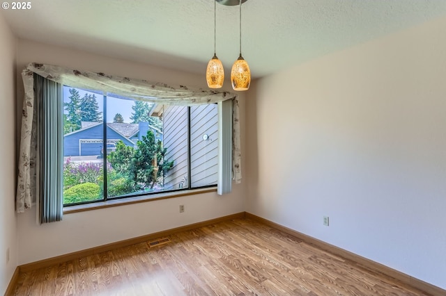 17708 SW Meadowbrook Way, Beaverton, OR 97078 - unfurnished dining area with light wood-type flooring, plenty of natural light, baseboards, and a textured ceiling