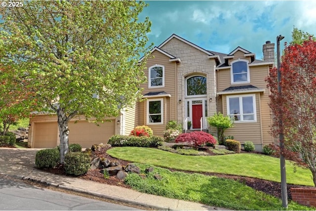 traditional-style house with an attached garage, concrete driveway, a front lawn, and stone siding