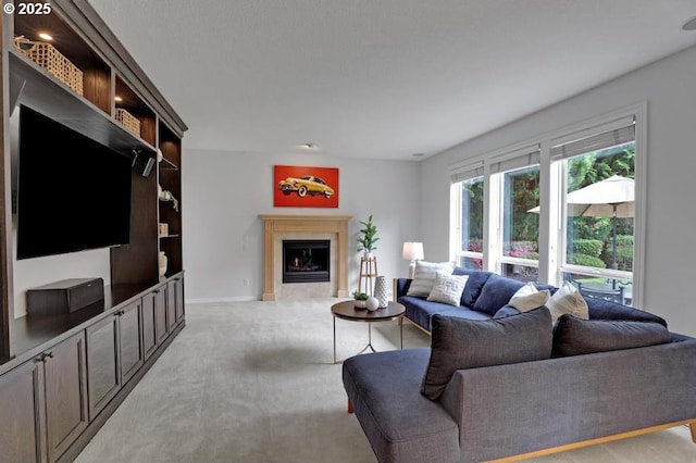living area featuring baseboards, light colored carpet, and a fireplace