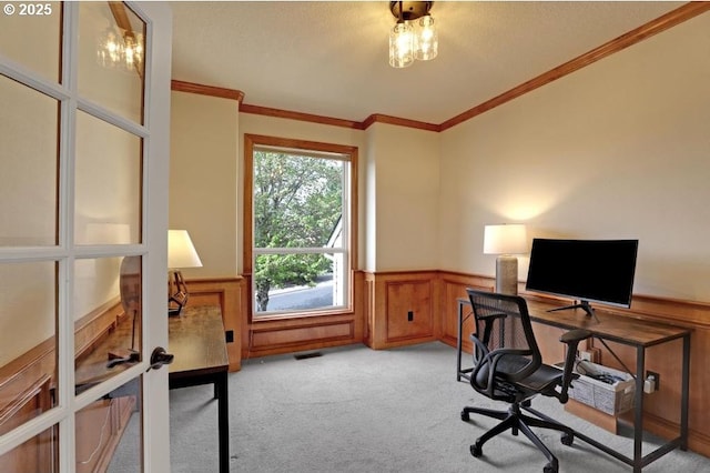 office featuring crown molding, a wainscoted wall, light carpet, and visible vents
