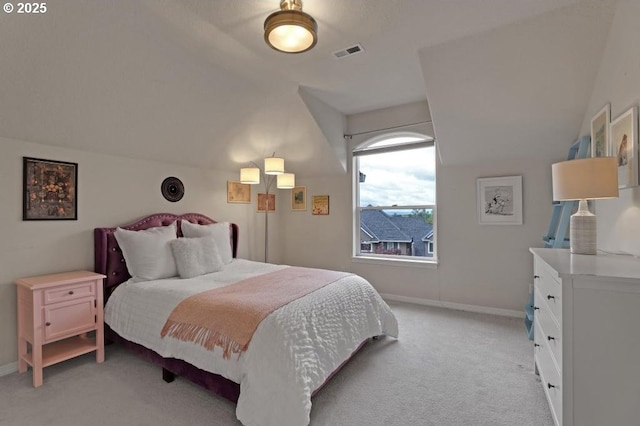 bedroom with baseboards, light colored carpet, lofted ceiling, and visible vents