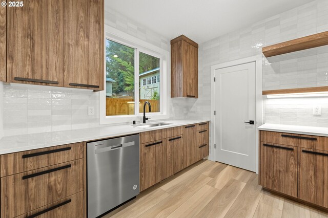 kitchen with a sink, stainless steel dishwasher, modern cabinets, and brown cabinetry