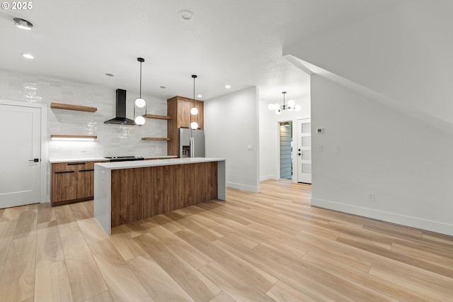 kitchen featuring light wood-type flooring, open shelves, stainless steel refrigerator with ice dispenser, wall chimney range hood, and tasteful backsplash