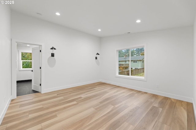 empty room featuring recessed lighting, light wood-type flooring, and baseboards