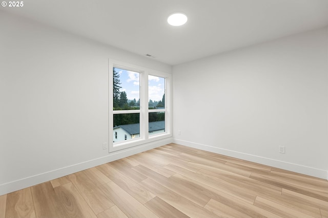 unfurnished room featuring visible vents, baseboards, and light wood-style floors