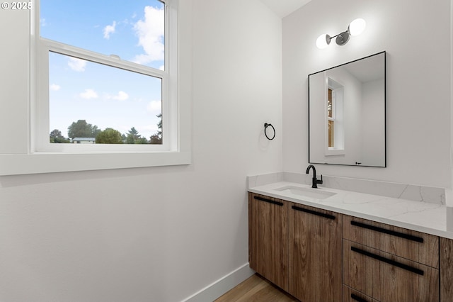 bathroom with vanity, baseboards, and wood finished floors