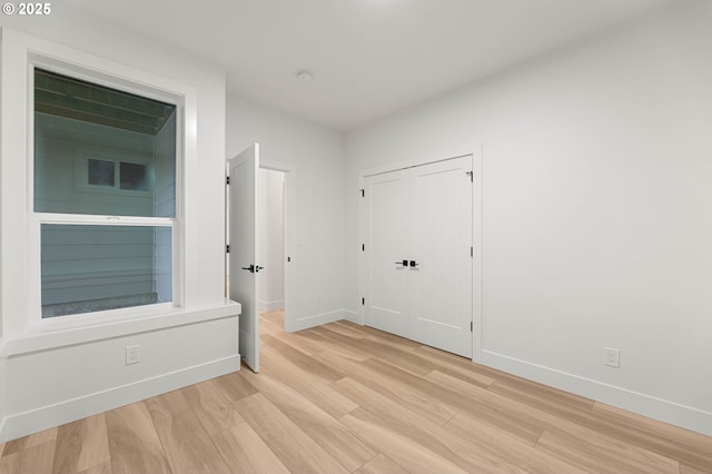 interior space featuring light wood-style flooring and baseboards