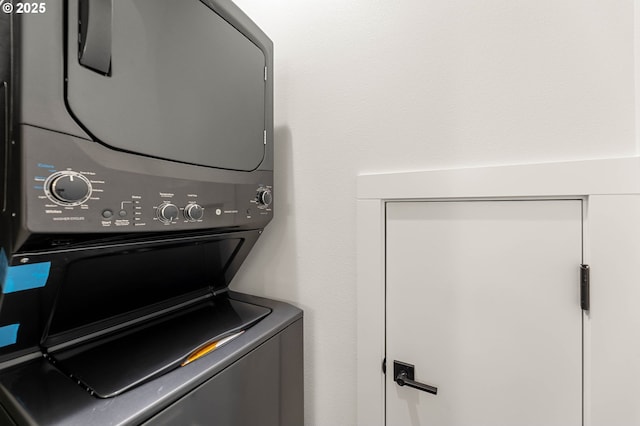 clothes washing area with laundry area and stacked washer and dryer