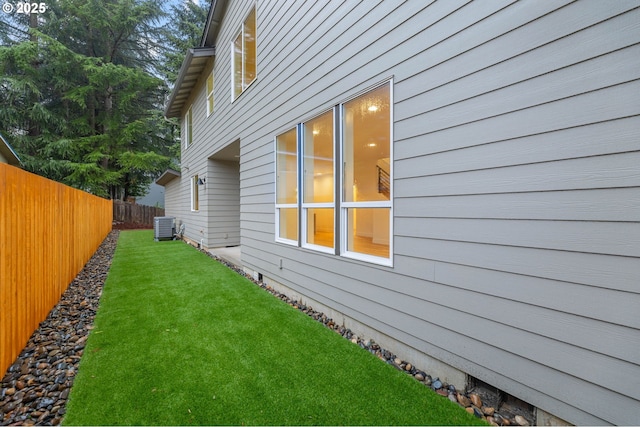 view of yard featuring central air condition unit and fence