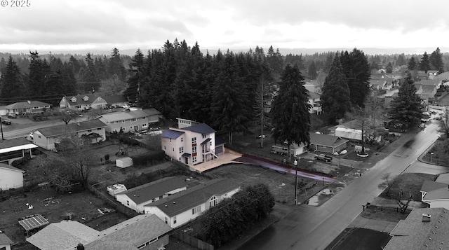 birds eye view of property featuring a residential view and a wooded view