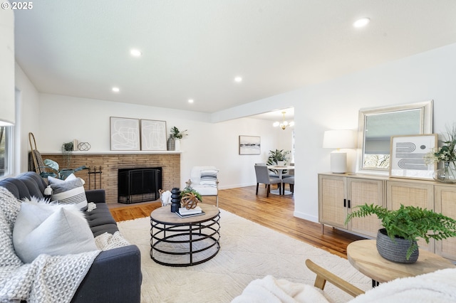 living room featuring baseboards, a fireplace, wood finished floors, and recessed lighting