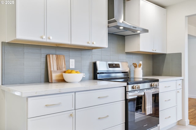 kitchen featuring light stone countertops, wall chimney exhaust hood, stainless steel electric stove, and tasteful backsplash