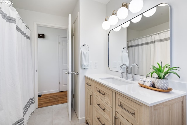 full bath featuring baseboards, vanity, and tile patterned floors