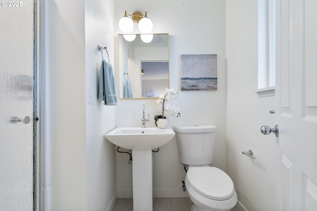 bathroom featuring toilet, baseboards, and tile patterned floors