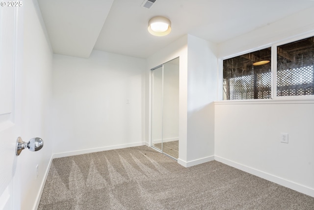 unfurnished bedroom featuring visible vents, a closet, baseboards, and carpet flooring