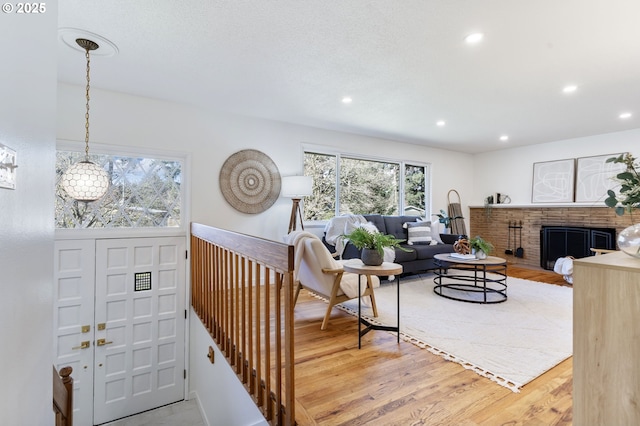 living room featuring recessed lighting, a fireplace, and light wood-style floors