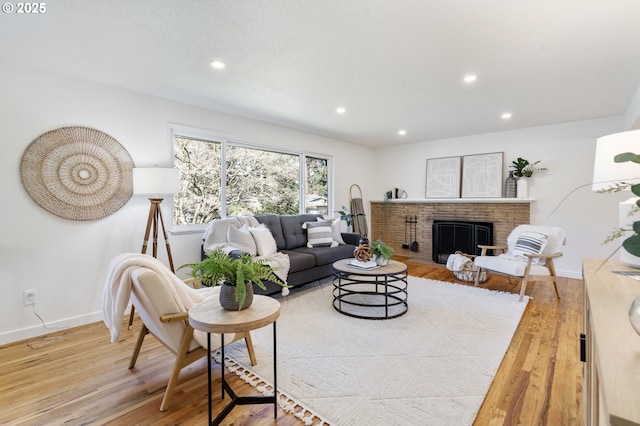 living room featuring recessed lighting, a fireplace, baseboards, and wood finished floors