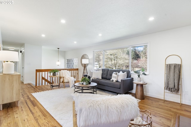 living room featuring baseboards, recessed lighting, light wood-type flooring, and a healthy amount of sunlight