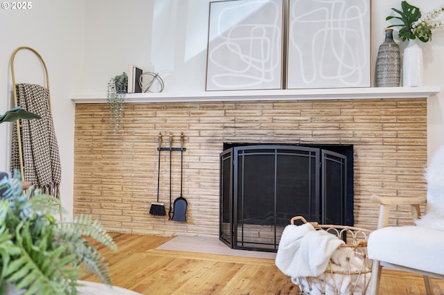 interior details with a brick fireplace and wood finished floors