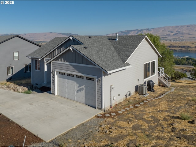 view of side of property with a garage, a mountain view, and central air condition unit