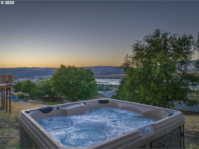 exterior space with a hot tub and a mountain view