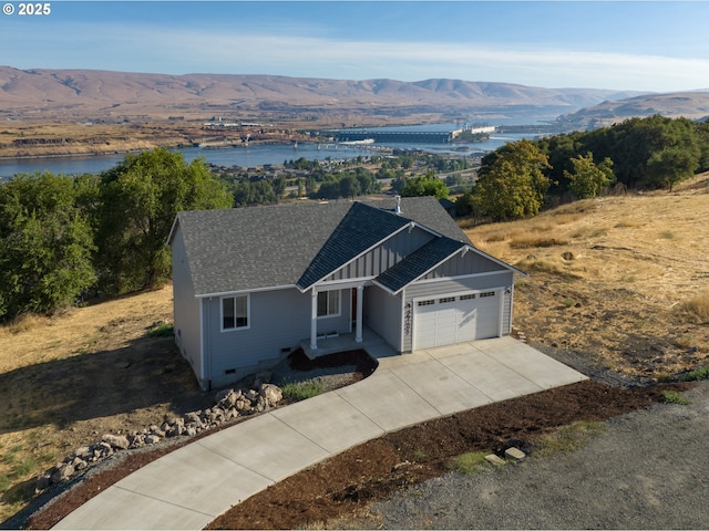 view of front of property with a garage and a water and mountain view