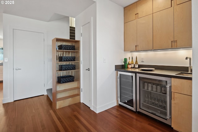 bar featuring wine cooler, sink, dark hardwood / wood-style flooring, and light brown cabinetry