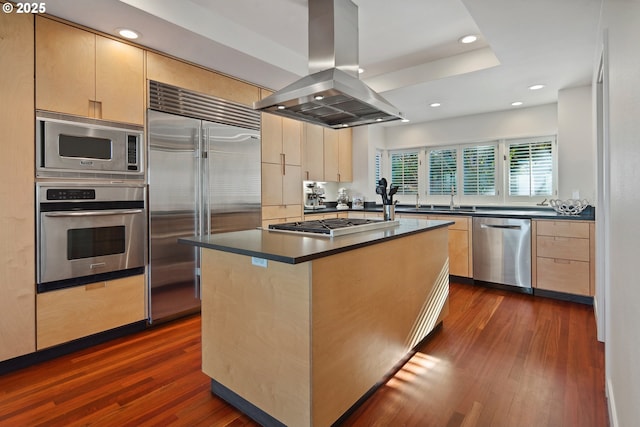 kitchen featuring light brown cabinetry, sink, island exhaust hood, built in appliances, and dark wood-type flooring