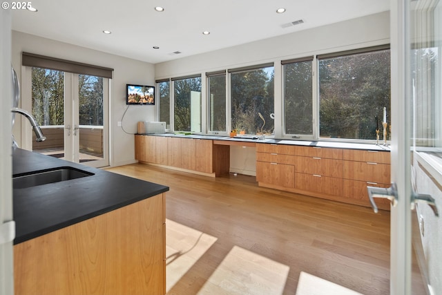 kitchen with sink, light hardwood / wood-style flooring, and french doors